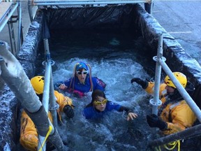 Looks of shock are frozen on volunteers' faces as they emerge from the water. ELISE SCHULZKE/POSTMEDIA