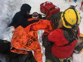 North Shore Rescue medical personnel work on a skier who triggered an avalanche in the back country near the Cypress ski area on March 4, 2017, and was swept over a small cliff and buried. His companion was able to dig out his face so he could breathe until rescuers arrived. The man was seriously injured and was flown by the rescue team's helicopter directly to a park near Lions Gate Hospital in North Vancouver. (North Shore Rescue/Facebook)