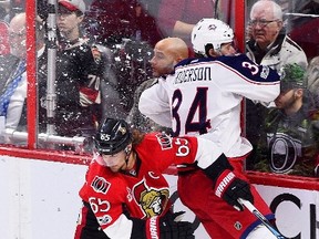 Senators defenceman Erik Karlsson slams Columbus Blue Jackets’ Josh Anderson into the boards during Saturday night’s game. (THE CANADIAN PRESS)