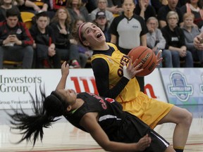 Queen's Gaels’ Emily Hazlett plays through a block from Carleton Ravens’ Jenjen Abella during the Ontario University Athletics women’s basketball gold-medal game Saturday night at the Queen's Athletic and Recreation Centre. Carleton won 49-41. (Ian MacAlpine/The Whig-Standard)