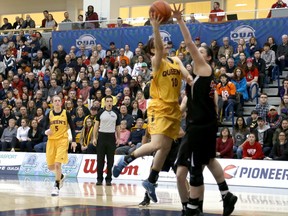 Carleton's Heather Lindsay defends Queen's Marianne Alarie during Saturday's OUA women's basketball final at Kingston.