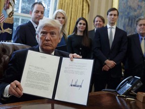 Donald Trump shows his signature on an executive order. (THE CANADIAN PRESS/AP/Evan Vucci)