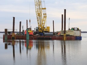 Workers on a barge build a temporary dock near Millhaven as part of the Amherst Island wind project on Monday. (Elliot Ferguson/The Whig-Standard)