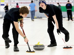 St. Patrick's Fighting Irish vice Andrew Mousseau, right, and lead Nick Gerrits sweep during the SWOSSAA boys curling final against the Ridgetown Royals at the Golden Acres Curling Club in Blenheim, Ont., on Monday, March 6, 2017. (Mark Malone/Chatham Daily News/Postmedia Network)