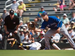 Pittsburgh Pirates second baseman Josh Harrison slides safely as Toronto Blue Jays first baseman Rowdy Tellez catches a throwback during Grapefruit League action in Bradenton, Fla., on Feb. 28, 2017. (THE CANADIAN PRESS/Nathan Denette)