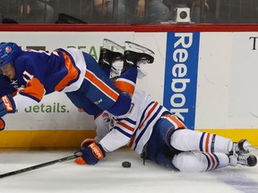 New York Islanders center Shane Prince (11) trips over Edmonton Oilers left-winger Milan Lucic on Nov. 5, 2016, in New York. The Oilers won 4-3 in a shootout. (AP Photo)