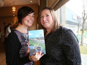 Latitude 46 Publishing co-publishers Laura Stradiotto, left, and Heather Campbell hold their first publication, Along the 46th, at a launch party in Sudbury, Ont. on Saturday November 14, 2015. John Lappa/Sudbury Star/Postmedia Network
