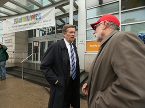 Toronto Mayor John Tory shakes hands with David Sadowski (R) outside the Miles Nadal Jewish Community Centre in the aftermath of a threat called in on Tuesday March 7, 2017. (Jack Boland/Toronto Sun)
