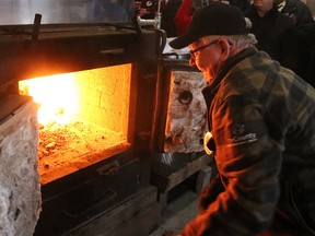 Prince Edward County Mayor Robert Quaiff feeds the evaporator at Sweetwater Cabin/Hubbs Sugarbush during the launch of Maple in the County, which takes place March 25-26. (BRUCE BELL/Postmedia network)