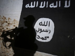 A member of the Iraqi forces walks past a mural bearing the logo of the Islamic State (IS) group in a tunnel that was reportedly used as a training centre by the jihadists, on March 1, 2017, in the village of Albu Sayf, on the southern outskirts of Mosul. (AHMAD AL-RUBAYE/AFP/Getty Images)