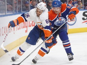 New York Islanders' Josh Ho-Sang (66) and Edmonton Oilers' Adam Larsson (6) battle for the puck during first period NHL action in Edmonton, Alta., on Tuesday, March 7, 2017.