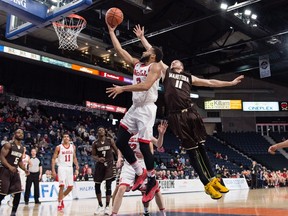 McGill Redmen's Dele Ogundokun, centre, scores against Manitoba Bisons' Joey Nitychoruk during first half USports basketball quarterfinal action in Halifax on Thursday, March 9, 2017.