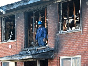 A Detroit Fire Department investigator stands on the second floor after a deadly fire at an apartment complex Wednesday, March 8, 2016, in Detroit. (Todd McInturf/Detroit News via AP)