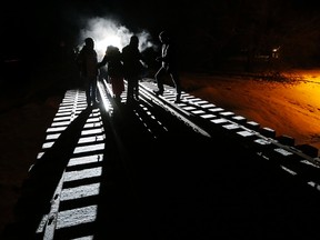 Migrants from Somalia cross into Canada from the United States by walking down a train track early Sunday, Feb. 26, 2017, into the town of Emerson, where they will seek asylum at the Canada Border Services Agency.