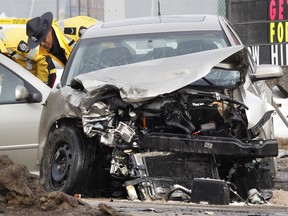 Edmonton Police Service members investigate a fatal two-vehicle crash involving an unmarked police vehicle on 75 Street at 76 Avenue in Edmonton on Thursday March, 8 2012. An 84-year-old woman died and the police officer received serious but non-life threatening injuries.