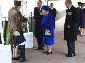 Michelle Lunn, left, holds on to her son Alfie, 2-years-old as they meet Britain's Queen Elizabeth II at the unveiling during the the unveiling of a national memorial honouring the Armed Forces and civilians who served their country during the Gulf War and conflicts in Iraq and Afghanistan in London Thursday March 9, 2017. Britain's Prince Philip stands at right(Toby Melville/Pool Via AP)