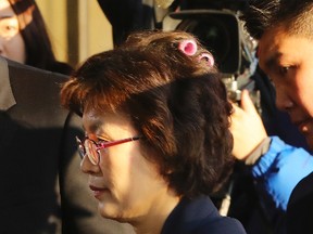 Acting Chief Justice Lee Jung-mi arrives with curlers in her hair at the Constitutional Court in Seoul, South Korea, Friday, March 10, 2017. In a historic, unanimous ruling Friday, South Korea's Constitutional Court formally removed impeached President Park Geun-hye from office over a corruption scandal that has plunged the country into political turmoil and worsened an already-serious national divide. (Kim Ju-sung/Yonhap via AP)