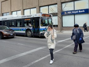 Pedestrians cross King Street at the corner of Richmond Street in front of an LTC bus on Friday March 10, 2017. (MORRIS LAMONT, The London Free Press)