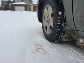 Blood stains on ground beside vehicle where knife wielding suspect was shot and killed by police yesterday near Hollands Landing and Holland Way in southwest Edmonton. (Photo by Larry Wong/Postmedia)