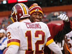 Injured Washington Redskins quarterback Robert Griffin III hugs Kirk Cousins after a win over the Cleveland Browns in an NFL game on Dec. 16, 2012. (AP Photo/Rick Osentoski)