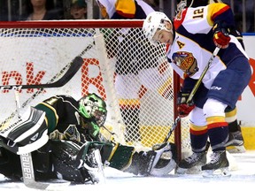 Knights goaltender Tyler Parsons reach back and keep the puck out of the net with Erie Otters star forward Alex DeBrincat looking for it in his skates during their OHL game at Budweiser Gardens on Friday night. DeBrincat scored into an empty net to seal the Otters? 4-1 win and stretch his goal streak to 19 games. (MIKE HENSEN, The London Free Press)