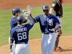 Jabari Blash of the Padres is greeted by teammates at the plate after hitting a home run on Tuesday. (Charlie Riedel, AP)
