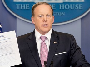 White House press secretary Sean Spicer holds up a Trump Administration document to "repeal and replace Obamacare" as he talks to the media during the daily press briefing at the White House in Washington, Friday, March 10, 2017. (AP Photo/Andrew Harnik)