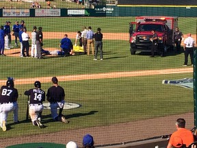 In this photo provided by Nick Brzezinski, players and staff watch as Toronto Blue Jays reliever T.J. House is tended to by emergency personnel after he was struck in the head by a line drive during a spring training game against the Detroit Tigers, Friday, March 10, 2017, in Lakeland, Fla. (Nick Brzezinski via AP)
