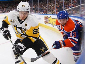 Pittsburgh Penguins' Sidney Crosby (87) and Edmonton Oilers' David Desharnais (13) vie for the puck during second period NHL action in Edmonton, Alta., on Friday, March 10, 2017.