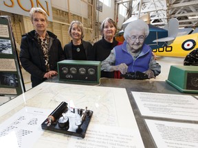 Geneve Fausak (left), Valerie Boyer and MaryBelle Thompson, daughters of aviation legend Hazel Fausak, pose with an interactive display commemorating their mother during the Women of Aviation Worldwide Week celebration being held at the Alberta Aviation Museum Saturday. (IAN KUCERAK/Postmedia)