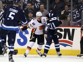Jets defenceman Jacob Trouba fights Calgary’s Sam Bennett during their game last night at the MTS Centre. The Flames, currently the hottest team in the league, beat Winnipeg 3-0. (Getty Images)