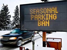 Cars pass by a sign announcing the parking ban, which starts Saturday morning, along Argyll Road near 86 Street in Edmonton, Alta., on Friday, Dec. 13, 2013. Codie McLachlan/Edmonton Sun