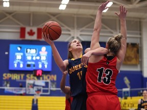 Queen's Gaels' Robyn Pearson holds off the Carleton Ravens' Nicole Gilmore as Pearson tries to tale a shot during second-half action in the bronze-medal game at the USports Women's Basketball Championship in Victoria, B.C., on Sunday. The Ravens won 53-43. (Chad Hipolito/The Canadian Press)