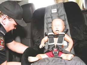 Firefighter on the Vulcan Fire Department Kevin Hansen clips a car seat into place during the Car Seat Technician course Thursday and Friday at the fire department. Hansen was one of five first responders to take the course.