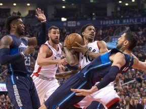 Toronto Raptors guard DeMar DeRozan is fouled by Dallas Mavericks centre Salah Mejri as guard Wesley Matthews and Raptors centre Jonas Valanciunas look on during an NBA game in Toronto on March 13, 2017. (THE CANADIAN PRESS/Chris Young)