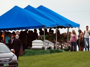 In this May 3, 2016, file photo, mourners gather around caskets for six of the eight members of the Rhoden family found shot April 22, 2016, at four properties near Piketon, Ohio, during funeral services at Scioto Burial Park in McDermott, Ohio. (AP Photo/John Minchillo, File)