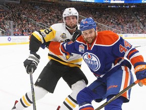 Pittsburgh Penguins' Brian Dumoulin and Edmonton Oilers' Zack Kassian vie for a puck along the boards in Edmonton on Friday, March 10, 2017. (The Canadian Press)