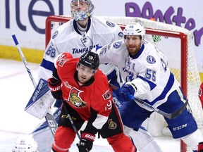 Tampa Bay goalie Andrei Vasilevskiy looks for the puck as teammate Braydon Coburn tries to keep the Senators’ Derick Brassard out of the crease last night at Canadian Tire Centre. (The Canadian Press)