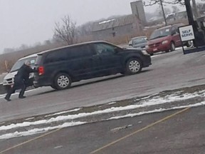 Photos posted to social media showing OPP Sgt. Glen Seddon pushing a van to an east London gas station have gone viral.  (Facebook photo)