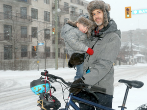 David Weatherall - photographed with his young son, Felix, 2, whom he bikes with in fairer weather, at the corner of McArthur and North River Road - is one of a growing number of cyclists worried about the new plan for a bike lane on McArthur Avenue. It goes nowhere, he says, and it has too much traffic to be safe. J(ulie Oliver/Postmedia)
