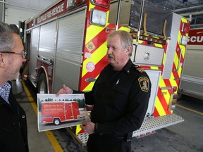 Jason Miller/The Intelligencer
Deputy Fire Chief Ray Ellis shows Brent Bullough, of Enbridge, a image of the new water supply trailer purchased with funds donated from Enbridge's Safe Community Program.