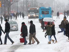 High school students and their parents walk across University Avenue near Queen's University during a March Break tour of Queen's during the snowstorm in Kingston on Wednesday.  (Ian MacAlpine/The Whig-Standard)