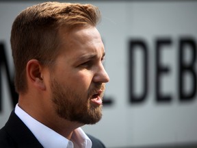 Derek Fildebrandt, stands in front of the Debt Clock that the Canadian Taxpayers Federation launched at McDougall Centre in Calgary, Alta. on Monday July 14, 2014.