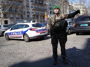 A soldier directs the traffic after letter bomb exploded at the French office of the International Monetary Fund, lightly injuring one person, Thursday March 16, 2017. A police official said no other damage was been reported in the incident. (AP Photo/Thibault Camus)