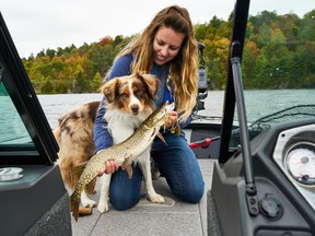 Columnist Ashley Rae with Blitz, her Miniature American Shepherd, and a northern pike. (Supplied photo)