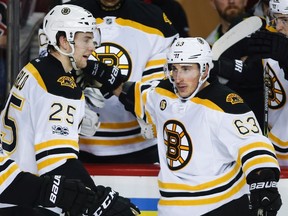 Boston Bruins' Brad Marchand, right, celebrates his goal with teammate Brandon Carlo during second period NHL hockey action against the Calgary Flames, in Calgary on Wednesday, March 15, 2017.