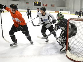 London Knights goaltender Tyler Parsons fields a rebound outside his goal crease with forward Owen MacDonald on the forecheck during practice at the Western Fair. (MORRIS LAMONT, The London Free Press)