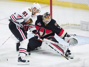 Ottawa Senators goalie Mike Condon keeps his eye on the puck as Chicago Blackhawks right winger Marian Hossa tries to score during an NHL game on March 16, 2017. (THE CANADIAN PRESS/Adrian Wyld)