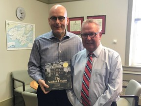 SUBMITTED PHOTO
Ontario Minister of Transportation Steven Del Duca (left) is pictured with a copy of The Settler's Dream he received from Prince Edward County Mayor Robert Quaiff during a Thursday morning visit at Shire Hall.