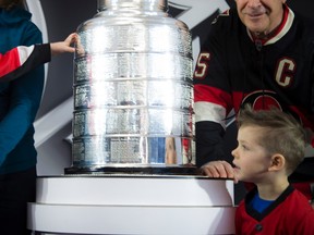 Lucas Mann, 2, gets a first-hand touch of the Stanley Cup during NHL Centennial Fan Van activities at the Aberdeen Pavilion on Saturday. Lucas was there with his brother Weston, 4.